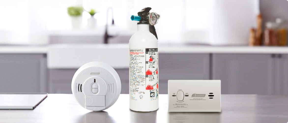 Un détecteur de fumée, un extincteur et un détecteur de monoxyde de carbone sur le comptoir d’une cuisine.
