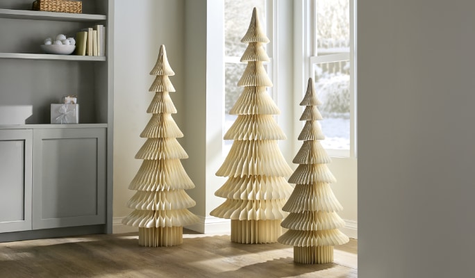 Un porte-bougie conique en laiton CANVAS Noël sur une table dans un salon.