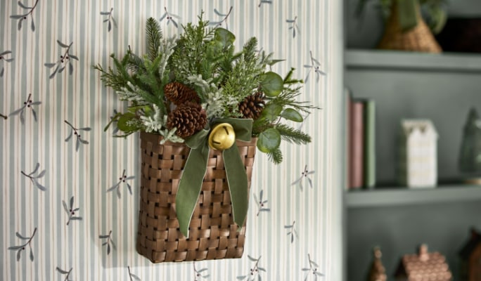 Une couronne de Noël floquée accrochée sur un mur dans un salon.