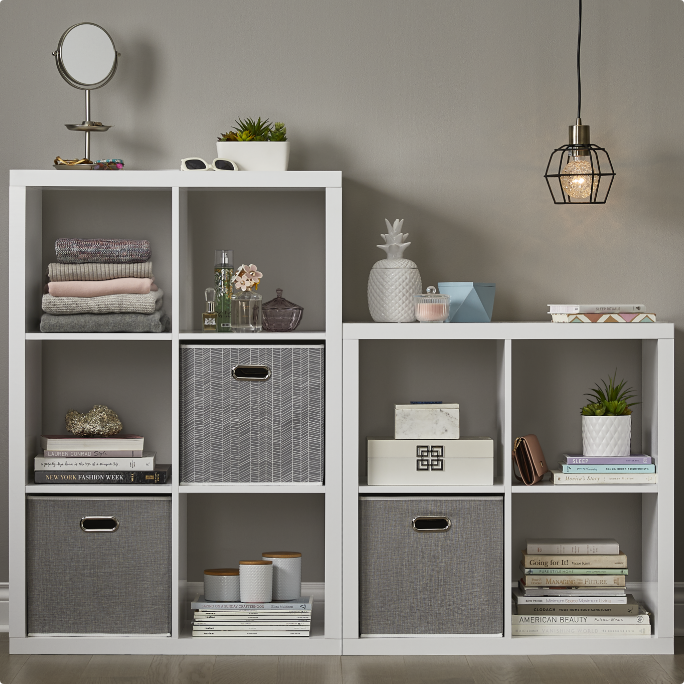 White cubby storage unit with various decorative items and baskets.