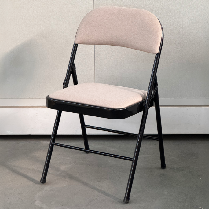 Black metal folding chair with a beige cushioned seat and backrest.