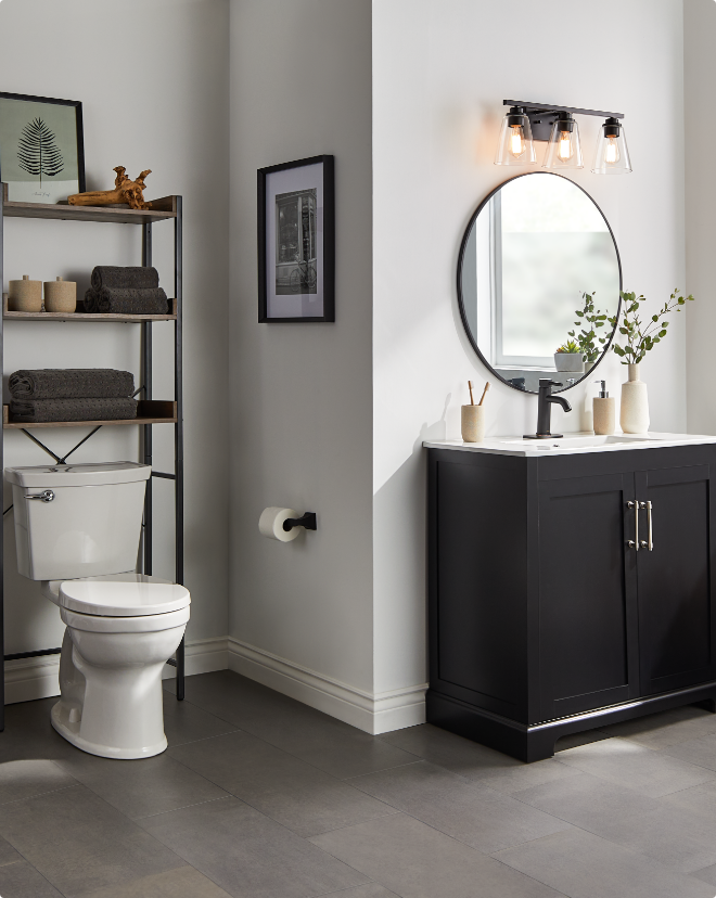 A modern bathroom with a toilet, sink vanity and wall-mounted mirror.