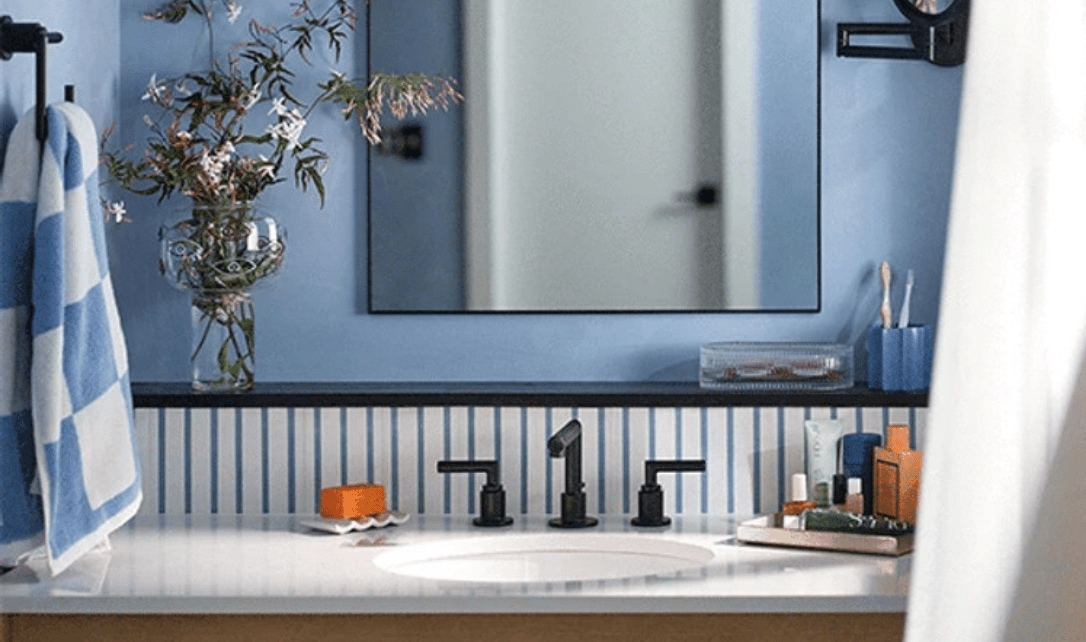 Un meuble de salle de bain doté d'une belle quincaillerie, d'un miroir rectangulaire et d'un décor coordonné.