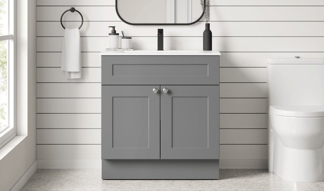 Une salle de bain équipée d'un meuble-lavabo gris classique, de luminaires simples et d'un design épuré et neutre.