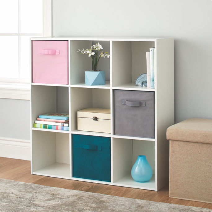 White cube shelving unit with various items, including baskets and decor pieces.