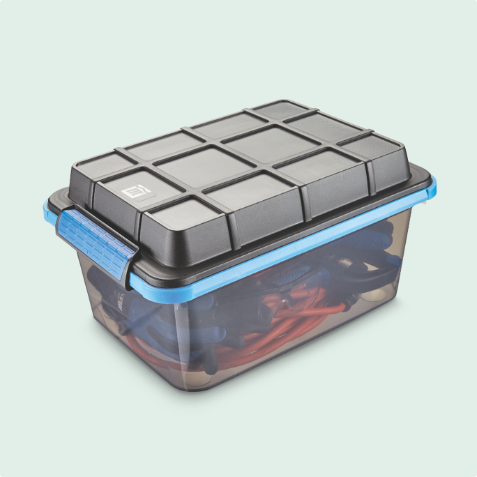 Clear small storage bin with a black lid, containing assorted items.