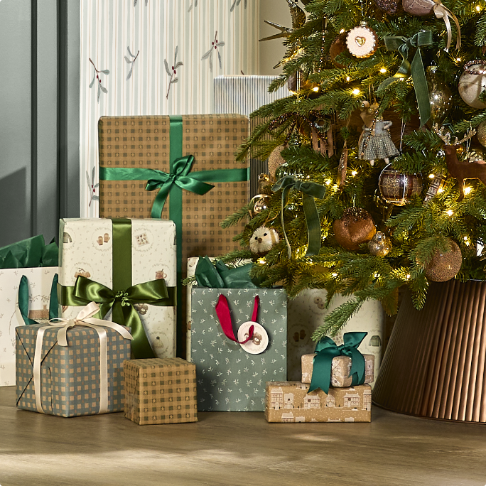 Un arbre de Noël avec des cadeaux magnifiquement emballés en dessous.