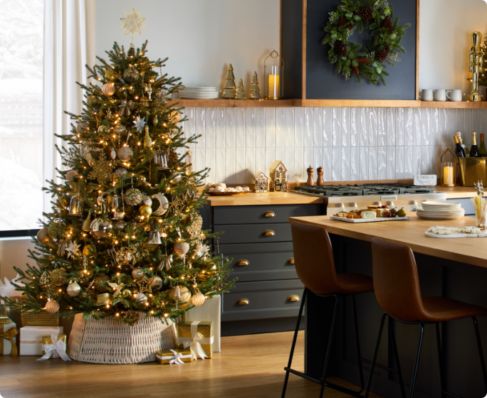 Une cuisine avec un arbre de Noël doré de la collection CANVAS Moments en or.