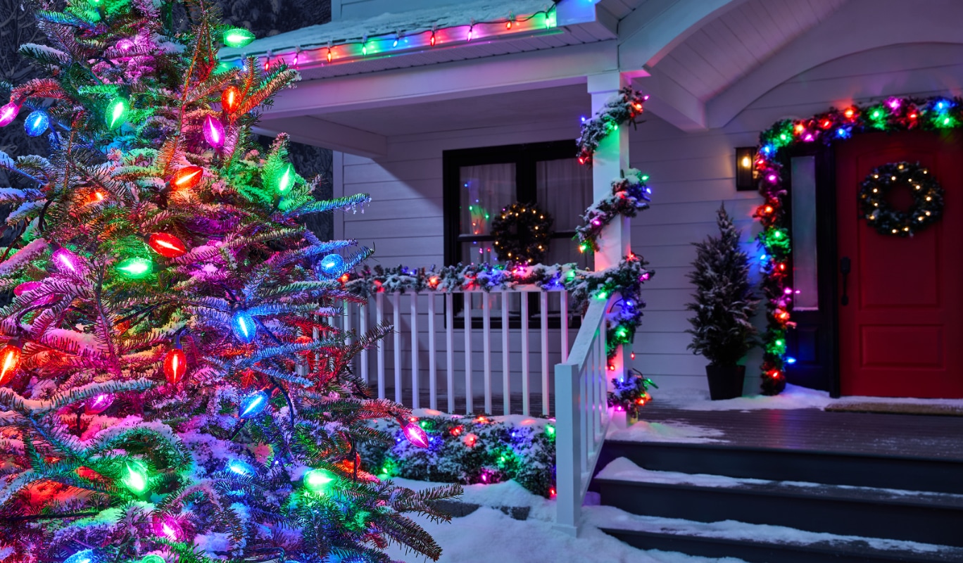 Une maison la nuit, décorée de guirlandes lumineuses colorées NOMA Big & Bright.