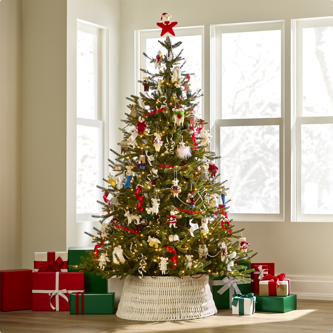 Christmas tree decorated with adorable mice ornaments and a red star topper, surrounded by wrapped gifts in a bright room.