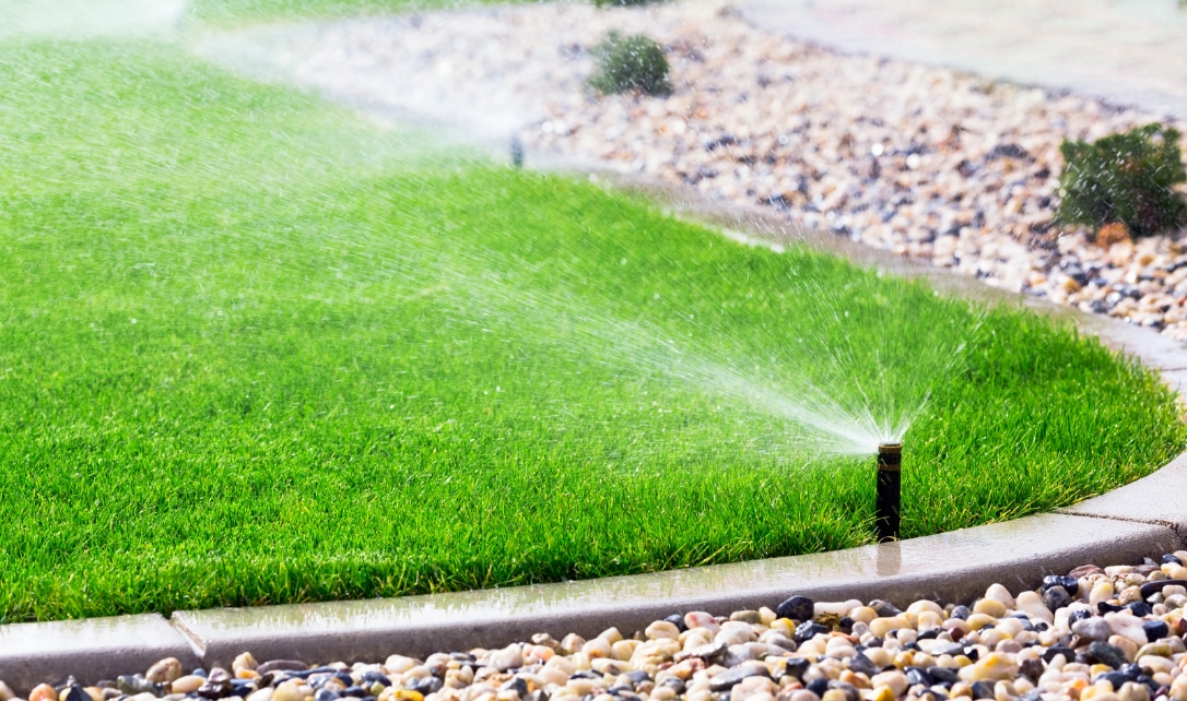  A lawn with sprinklers watering the grass. 