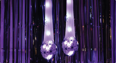A hanging LED spider egg sack Halloween decoration with glowing lights.