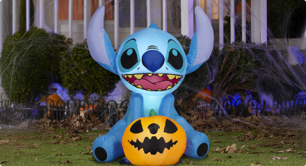 A Stitch inflatable Halloween decoration holding a jack-o'-lantern.