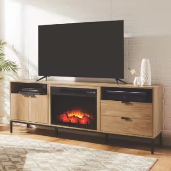 A TV mounted on a wooden entertainment unit with a built-in electric fireplace, located in a cozy living room.