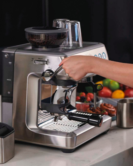 Une machine à espresso moderne sur un comptoir avec divers accessoires et ingrédients pour faire du café.