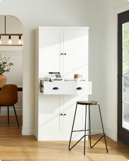 A modern kitchen with white cabinets and a bar stool.