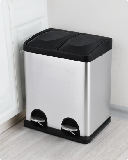 A dual-compartment stainless steel trash and recycling bin.