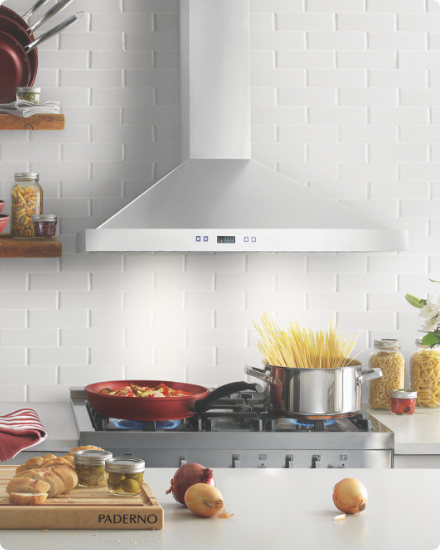 A stove with pots and pans under a stainless steel range hood.