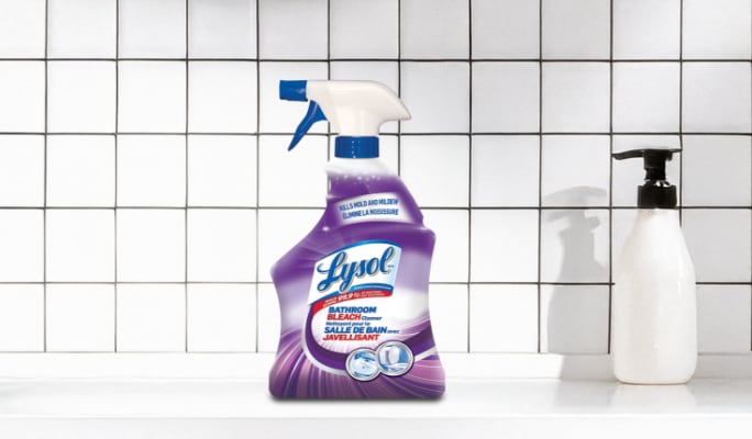 Purple spray bottle of Lysol bathroom cleaner on a white tiled countertop.