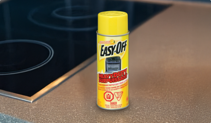Yellow can of EASY OFF kitchen cleaner on a stovetop.