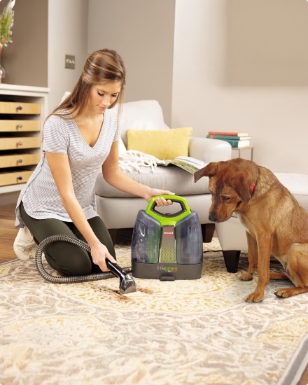 Une femme utilise un nettoyant à tapis sur son tapis.