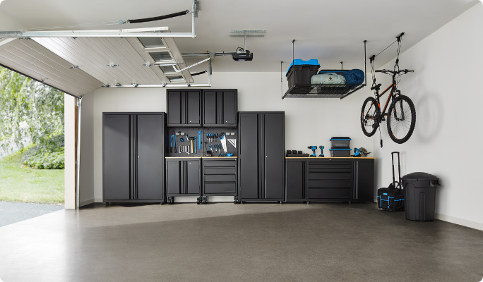 Organized garage with storage cabinets, shelves, bins and various tools neatly arranged.