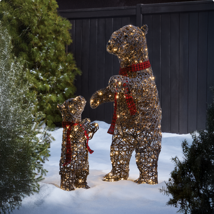 Light-up bear and cub decorations standing in a snowy garden. 
