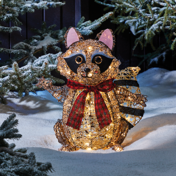 A cheerful light-up raccoon decoration wearing a red plaid scarf.