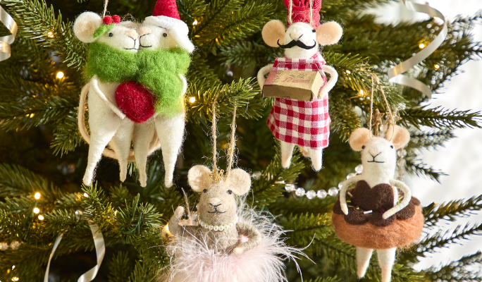 An assortment of CANVAS mouse ornaments hanging on a Christmas tree.
