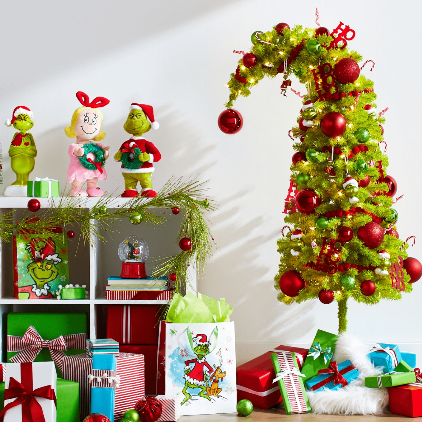 Un arbre Crumpit For Living de 4,5 pi et divers articles de décoration sur le thème du Grincheux disposés dans une pièce lumineuse.