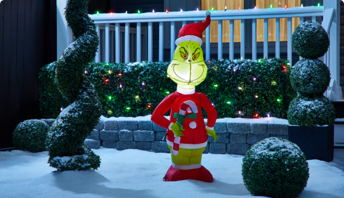 Décoration gonflable Airblown du Grincheux dans une cour enneigée.