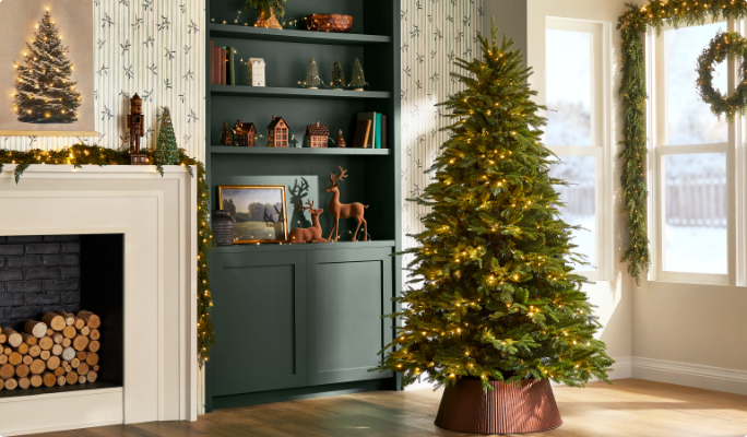 Decorated Christmas tree in a living room with a fireplace, shelves with holiday decor, and a window with a wreath.