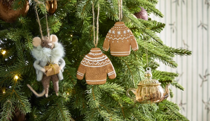 Christmas decorations and ornaments including gingerbread and angel ornaments hanging on a Christmas tree.