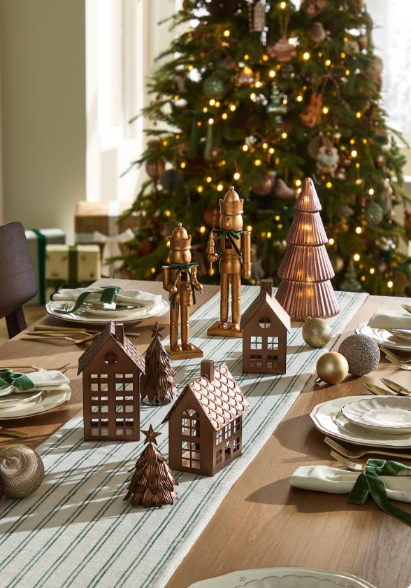 Siège vitré avec coussins de Noël CANVAS et décorations sur une table.