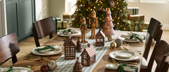 Siège vitré avec coussins de Noël CANVAS et décorations sur une table.