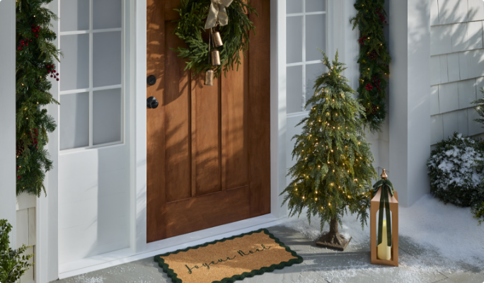 Assortiment de décorations de Noël, guirlandes et couronnes sur le porche avant.