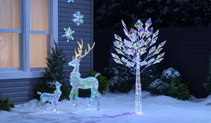 CANVAS Glisten Pre-lit decorations in a snowy yard.