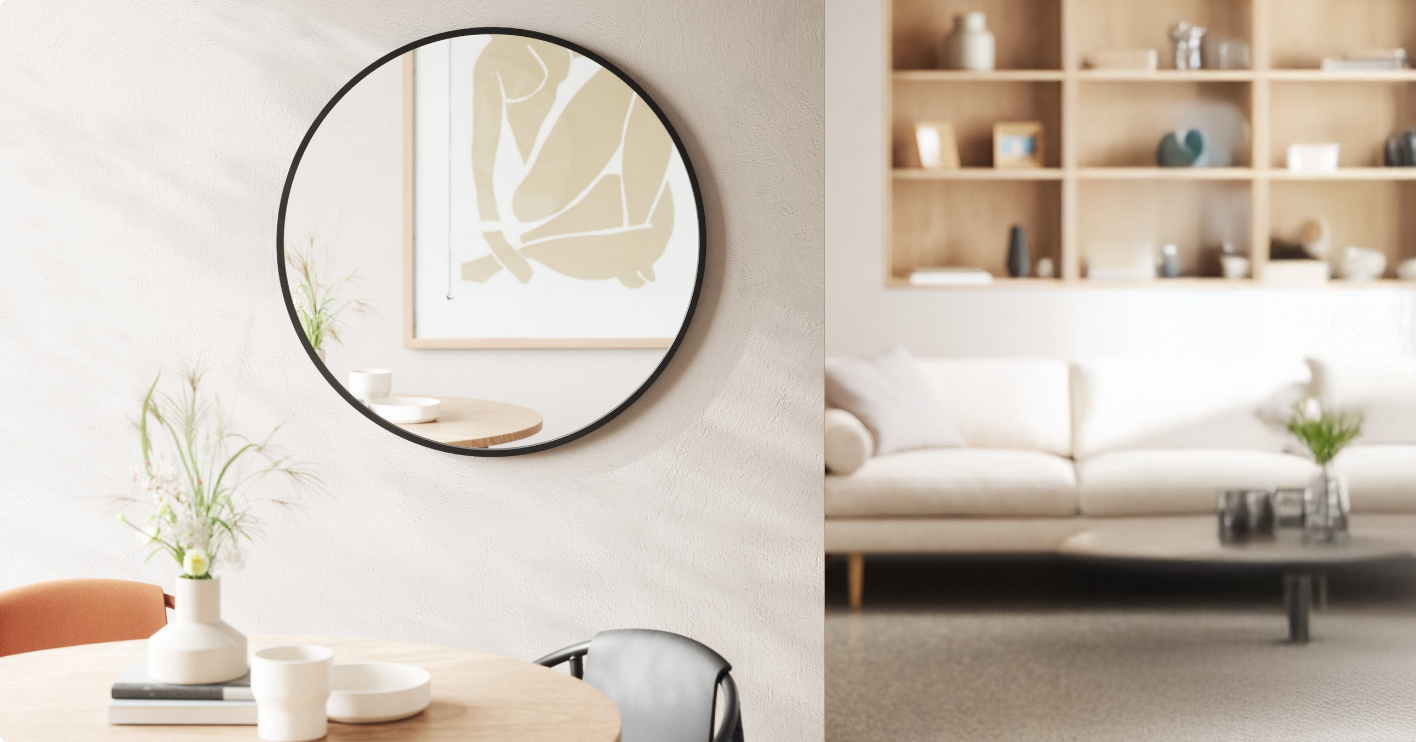  A modern living space with a round mirror on the wall, reflecting abstract artwork.