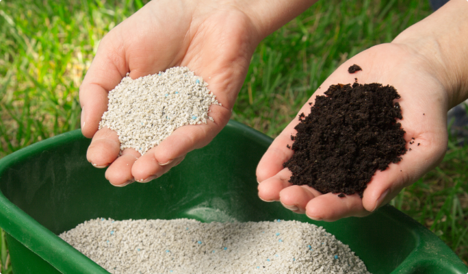 Mains tenant de l’engrais et de la terre.