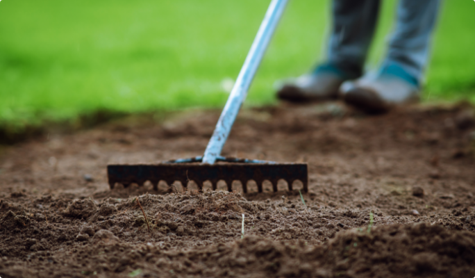 Personne râtelant le sol.