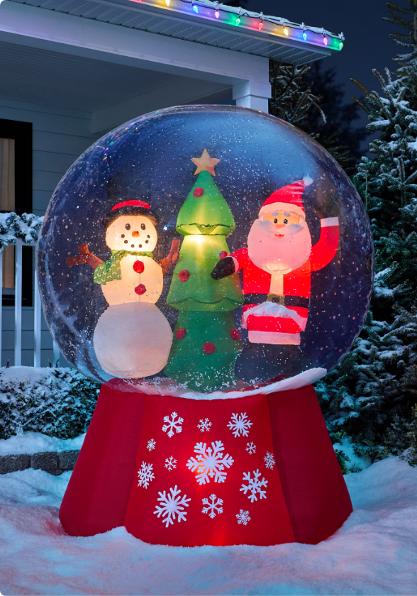 Une décoration Snuggles le bonhomme de neige CANVAS dans une cour avant enneigée la nuit.