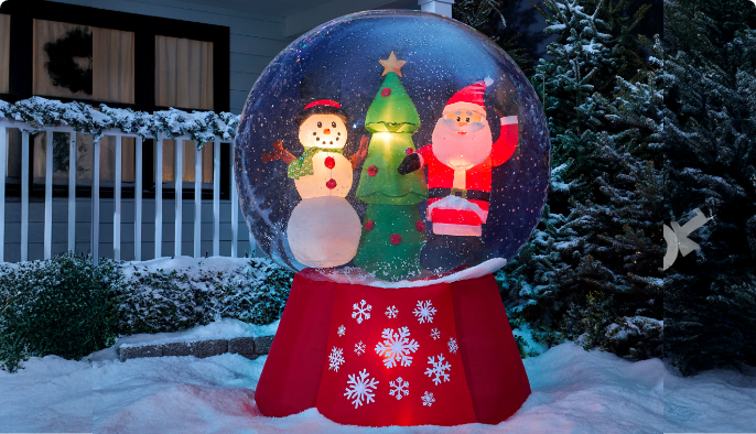 Une décoration Snuggles le bonhomme de neige CANVAS dans une cour avant enneigée la nuit.