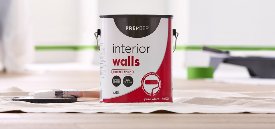 A can of interior wall paint with brush.