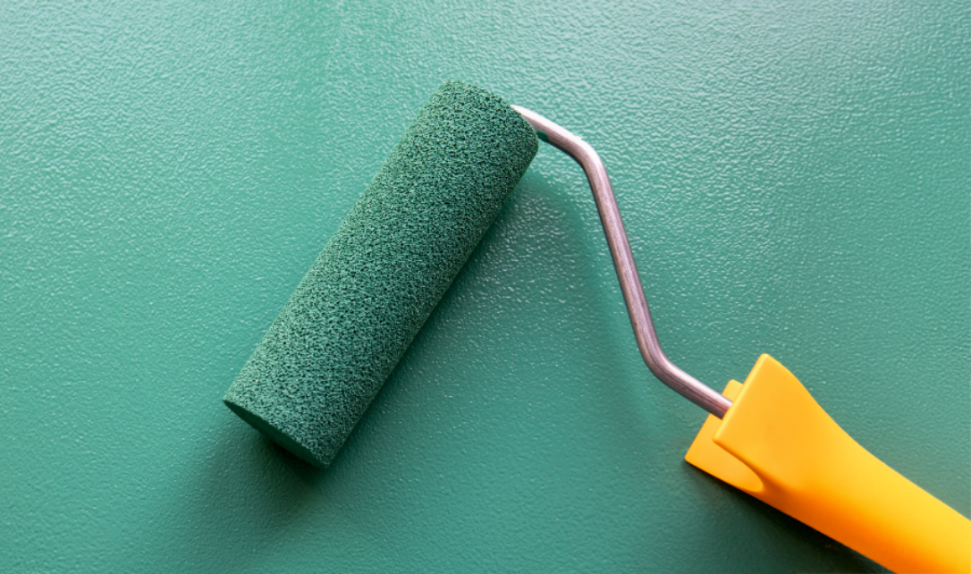 Paint roller on green wall.