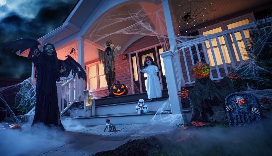 A group of people in costumes celebrating in a room decorated for Halloween.