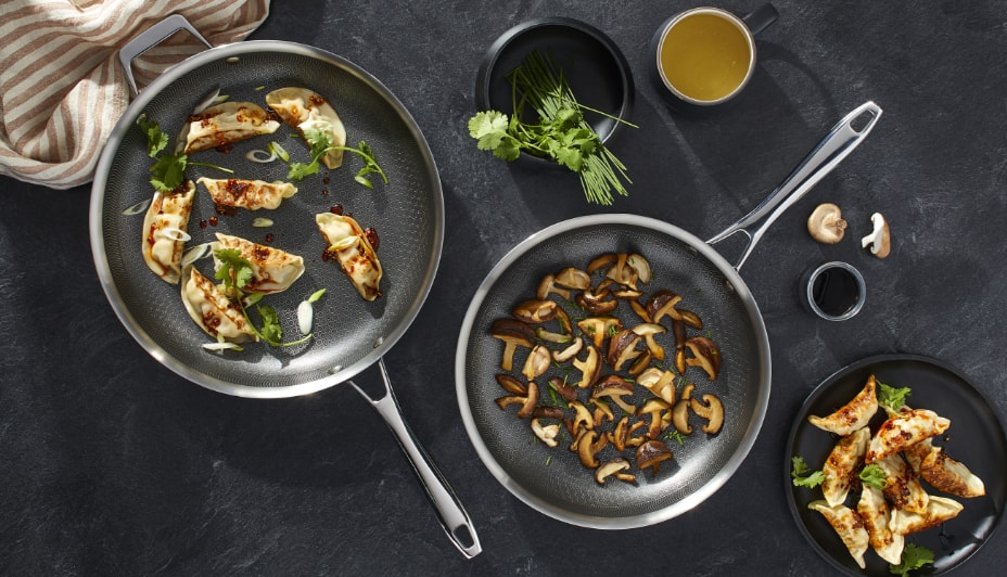 Food cooking in three pans of different sizes.