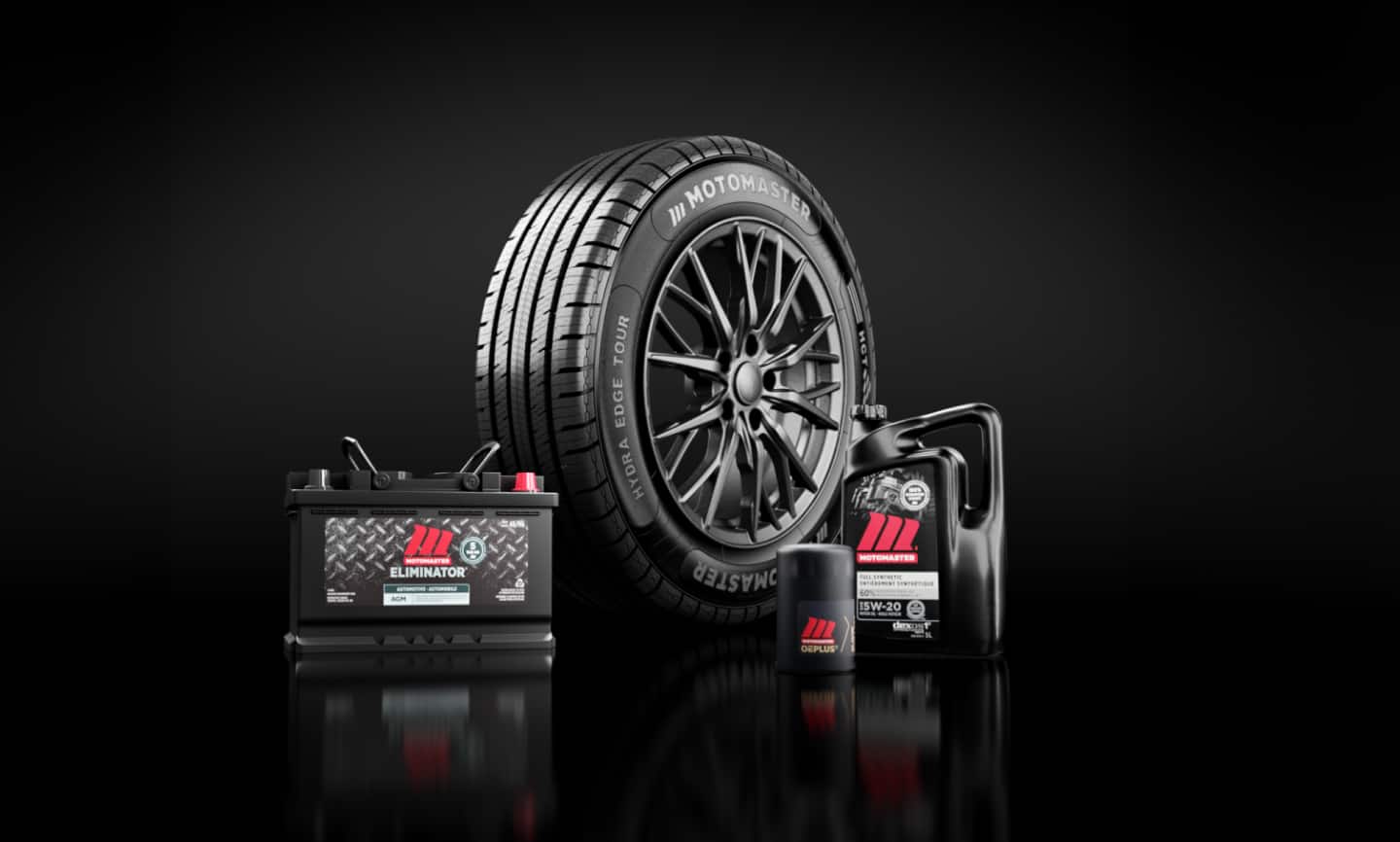 Un pneu, une batterie de voiture, un filtre à huile et un bidon d’huile à moteur MotoMaster disposés en groupe.