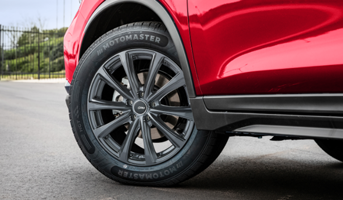 A MotoMaster tire on a red truck.