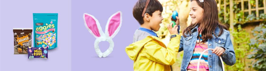 Pack of Cadbury Caramilk Eggs, a bag of Cadbury Mini Eggs, and a bag of Hershey Eggies.  A white and pink plush bunny ears headband.   Two children holding Easter eggs and a basket. 