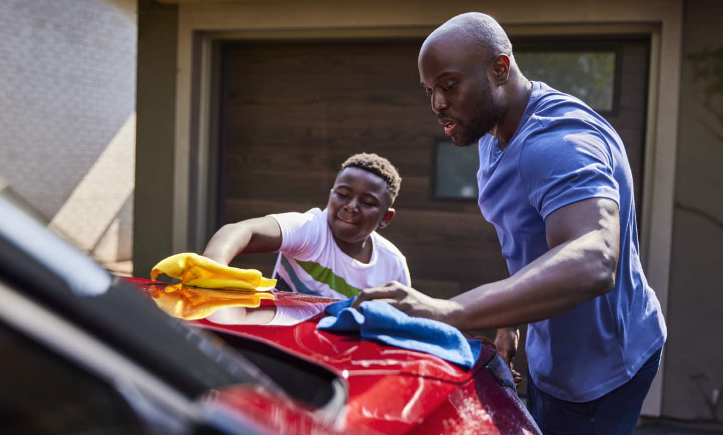 A father and son cleaning a car with Simoniz Microfibre towels.